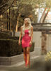 blonde girl with long blonde hair walking in a bright pink dress