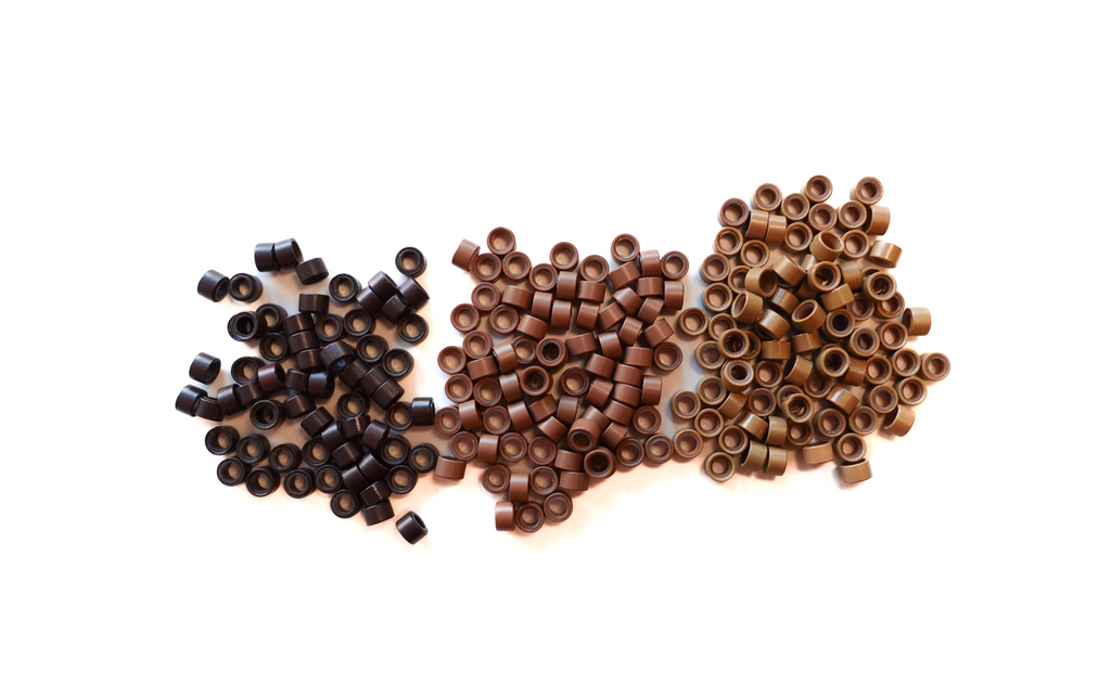 Dark brown beads, light brown beads and blonde beads scattered in piles beside eachother to show color difference
